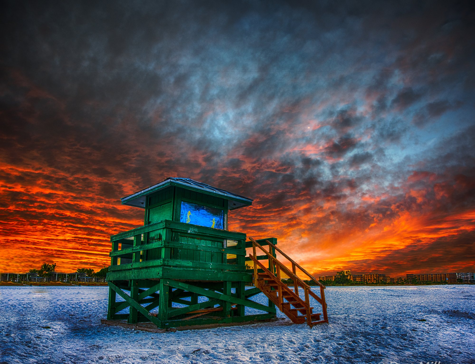 Green Siesta Key lifeguard stand against a colorful sunrise sky